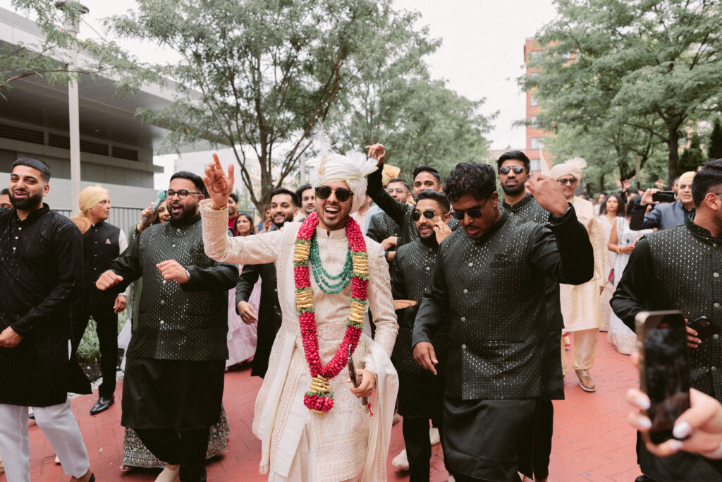 Groom and friends dance and enjoy themselves during baraat