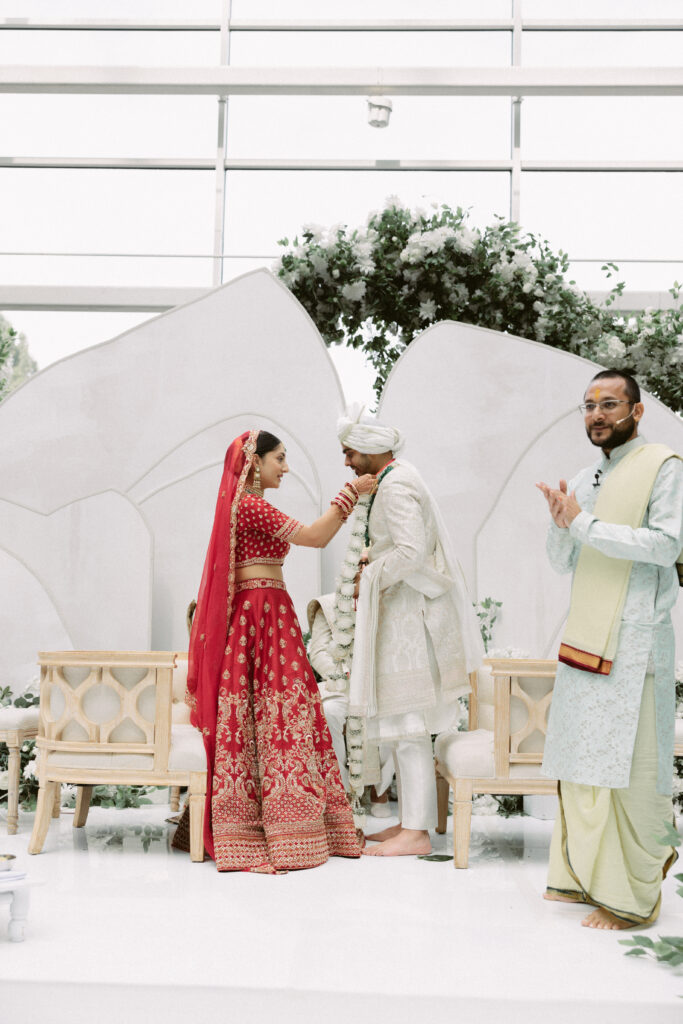 Bride and groom in traditional attire perform a sacred South Asian wedding ritual under the mandap at the Gaylord National Resort.