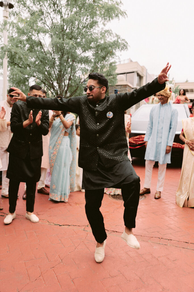 Groom’s family and friends joyfully dancing during the lively baraat procession outside the Gaylord National Resort.