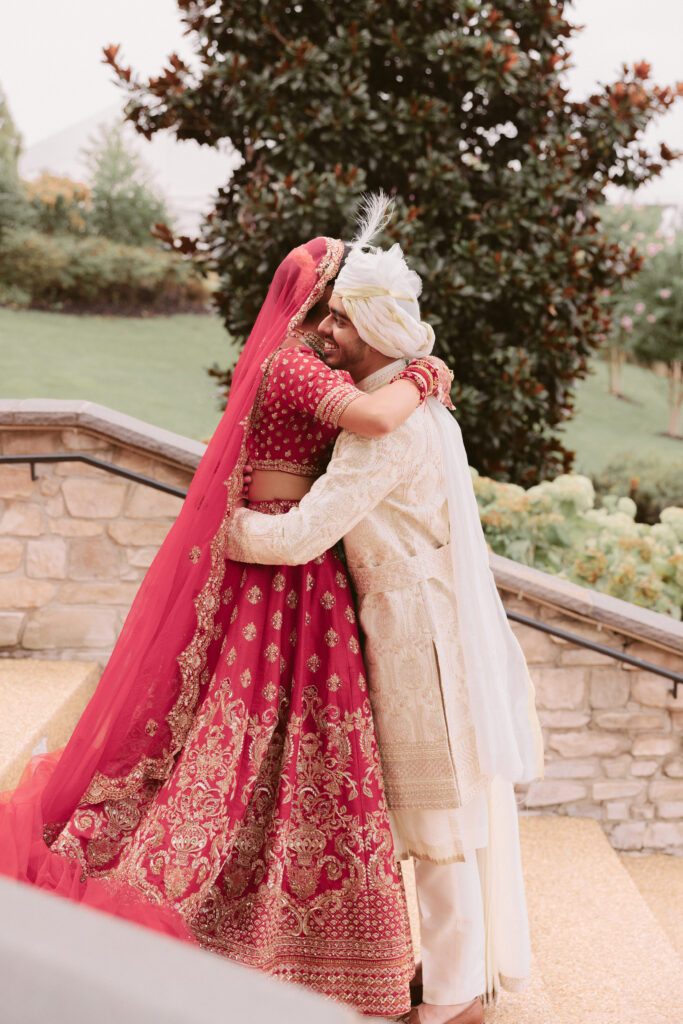 South Asian couple embraces after seeing each other for the first time on their wedding day